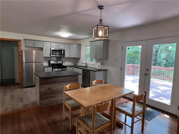a kitchen with a dining table chairs and refrigerator