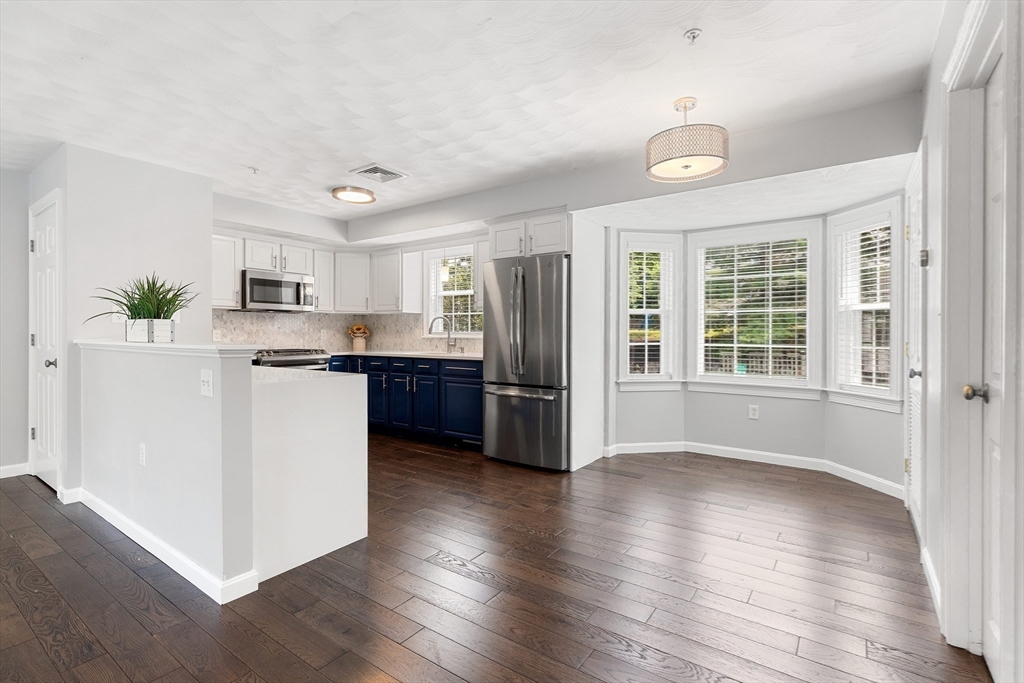2 Ricciuti Drive, Unit 9 Quincy, MA 02169 - Photo 10 of 40 a kitchen with stainless steel appliances granite countertop a refrigerator and a stove top oven