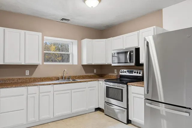 a kitchen with stainless steel appliances granite countertop a refrigerator and a stove