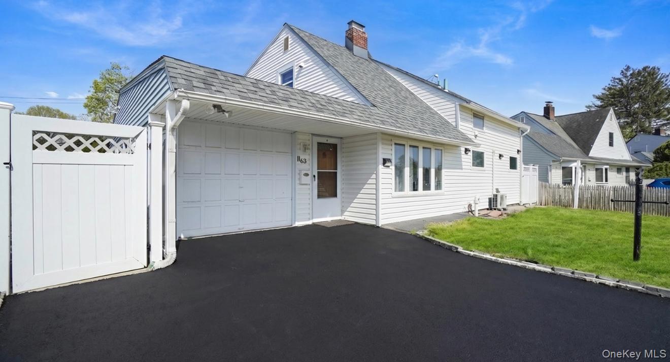 63 Blacksmith Road Levittown, NY 11756 - Photo 2 of 25 White siding exterior with an attached garage and a paved driveway