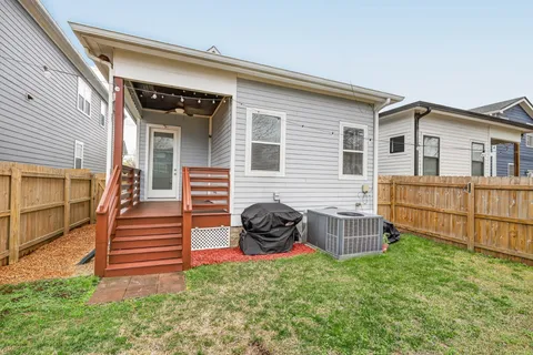 a view of a house with backyard and wooden fence