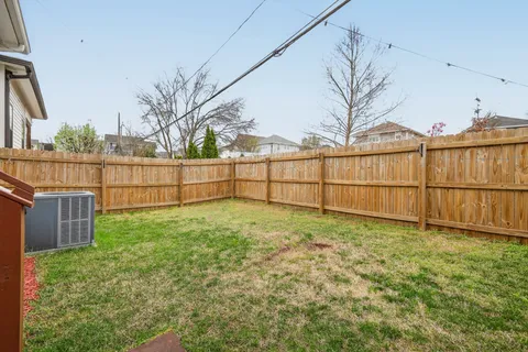 a view of backyard with wooden fence