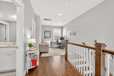a view of a hallway with dining room and wooden floor