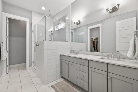 a spacious bathroom with a double vanity sink shower and a mirror