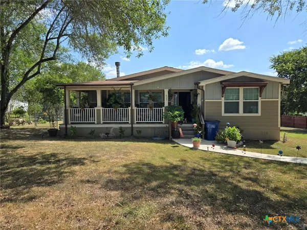 a view of a house with backyard and sitting area