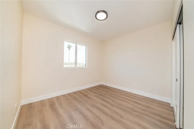 an empty room with wooden floor and window