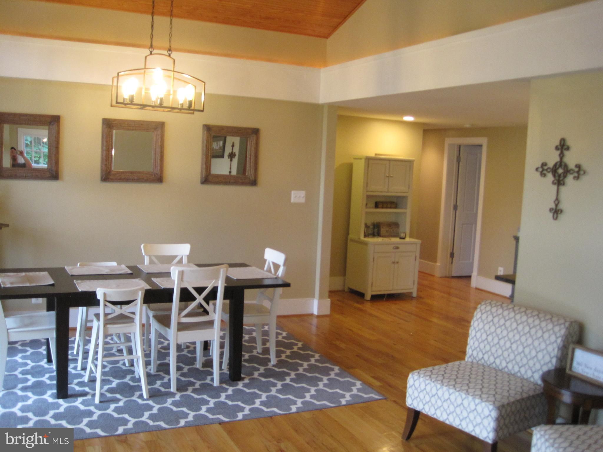 222 Stringtown Road Berryville, VA 22611 - Photo 10 of 29 a living room with furniture a dining table and a chandelier