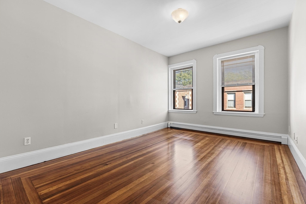 32-34 Ditson Street, Unit 6 Boston, MA 02122 - Photo 12 of 27 a view of an empty room with wooden floor and a window