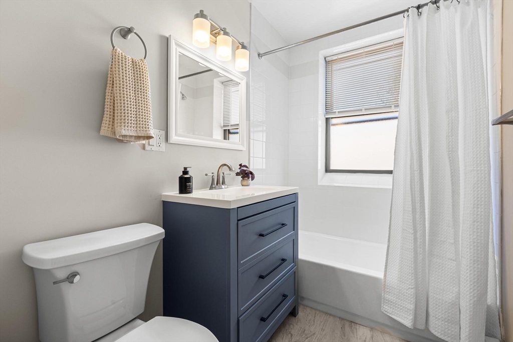 32-34 Ditson Street, Unit 6 Boston, MA 02122 - Photo 13 of 27 a bathroom with a toilet sink vanity and mirror