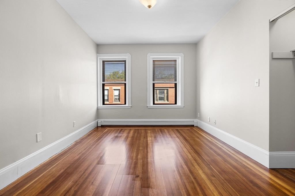 32-34 Ditson Street, Unit 6 Boston, MA 02122 - Photo 15 of 27 a view of an empty room with wooden floor and a window