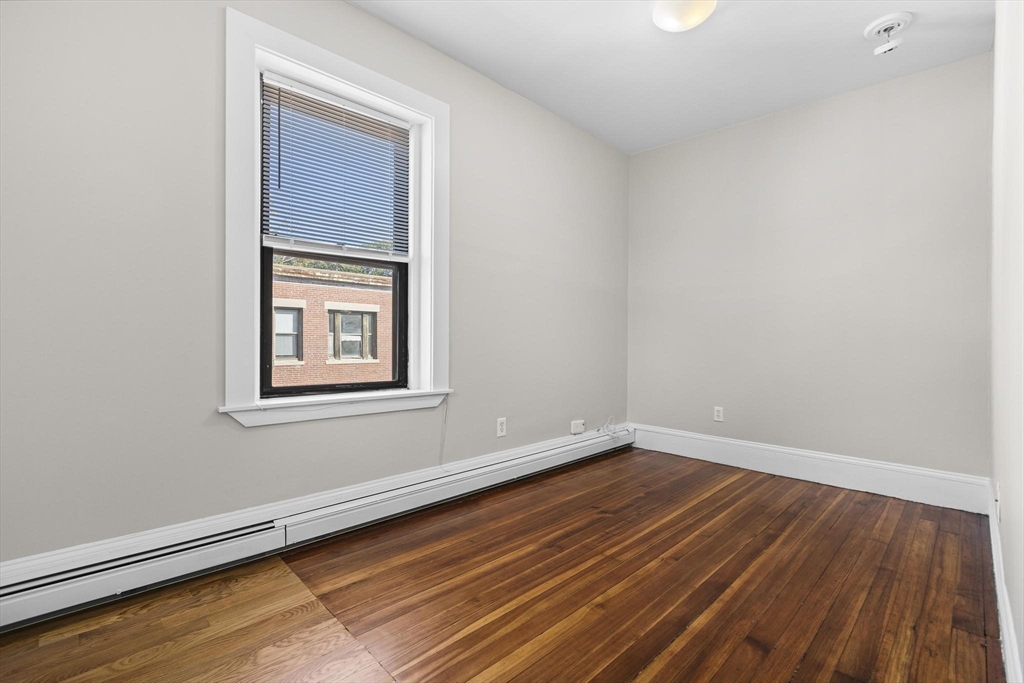 32-34 Ditson Street, Unit 6 Boston, MA 02122 - Photo 17 of 27 an empty room with wooden floor and windows
