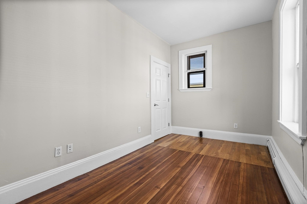 32-34 Ditson Street, Unit 6 Boston, MA 02122 - Photo 18 of 27 a view of an empty room with wooden floor and a window