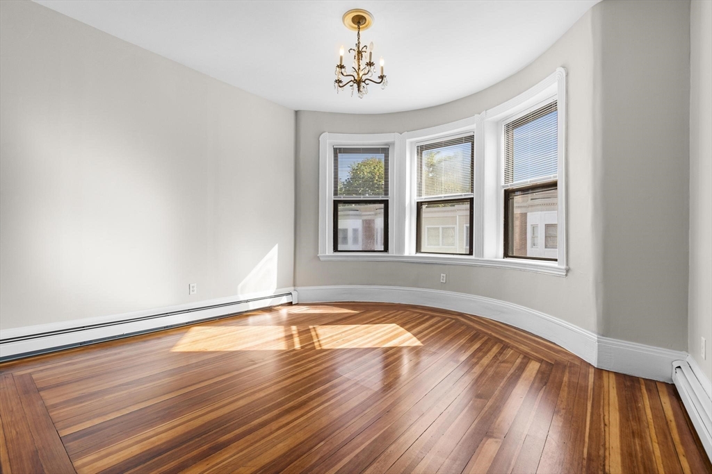 32-34 Ditson Street, Unit 6 Boston, MA 02122 - Photo 2 of 27 a view of an empty room with window and wooden floor