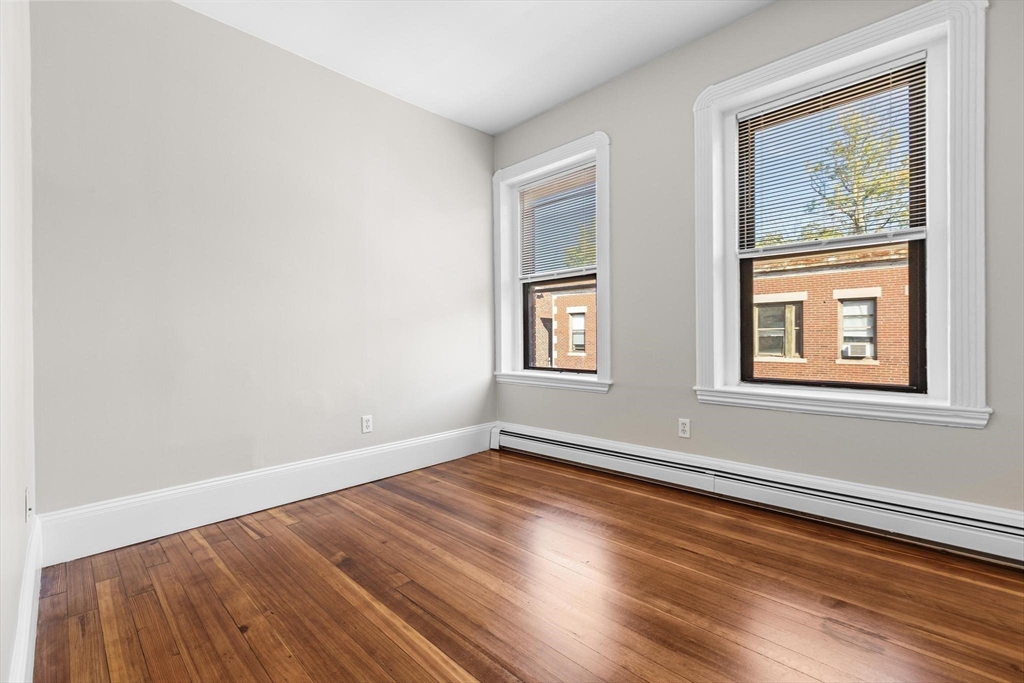 32-34 Ditson Street, Unit 6 Boston, MA 02122 - Photo 4 of 27 an empty room with wooden floor and windows