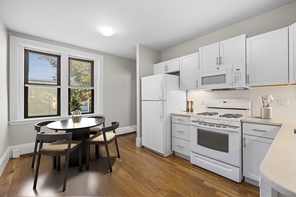 32-34 Ditson Street, Unit 6 Boston, MA 02122 - Photo 8 of 27 a kitchen with a stove a refrigerator and a dining table