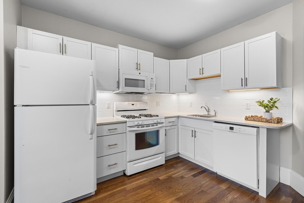 32-34 Ditson Street, Unit 6 Boston, MA 02122 - Photo 9 of 27 a kitchen with white cabinets and white appliances