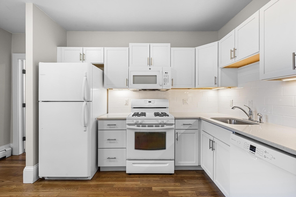 32-34 Ditson Street, Unit 6 Boston, MA 02122 - Photo 10 of 27 a kitchen with cabinets appliances and wooden floor