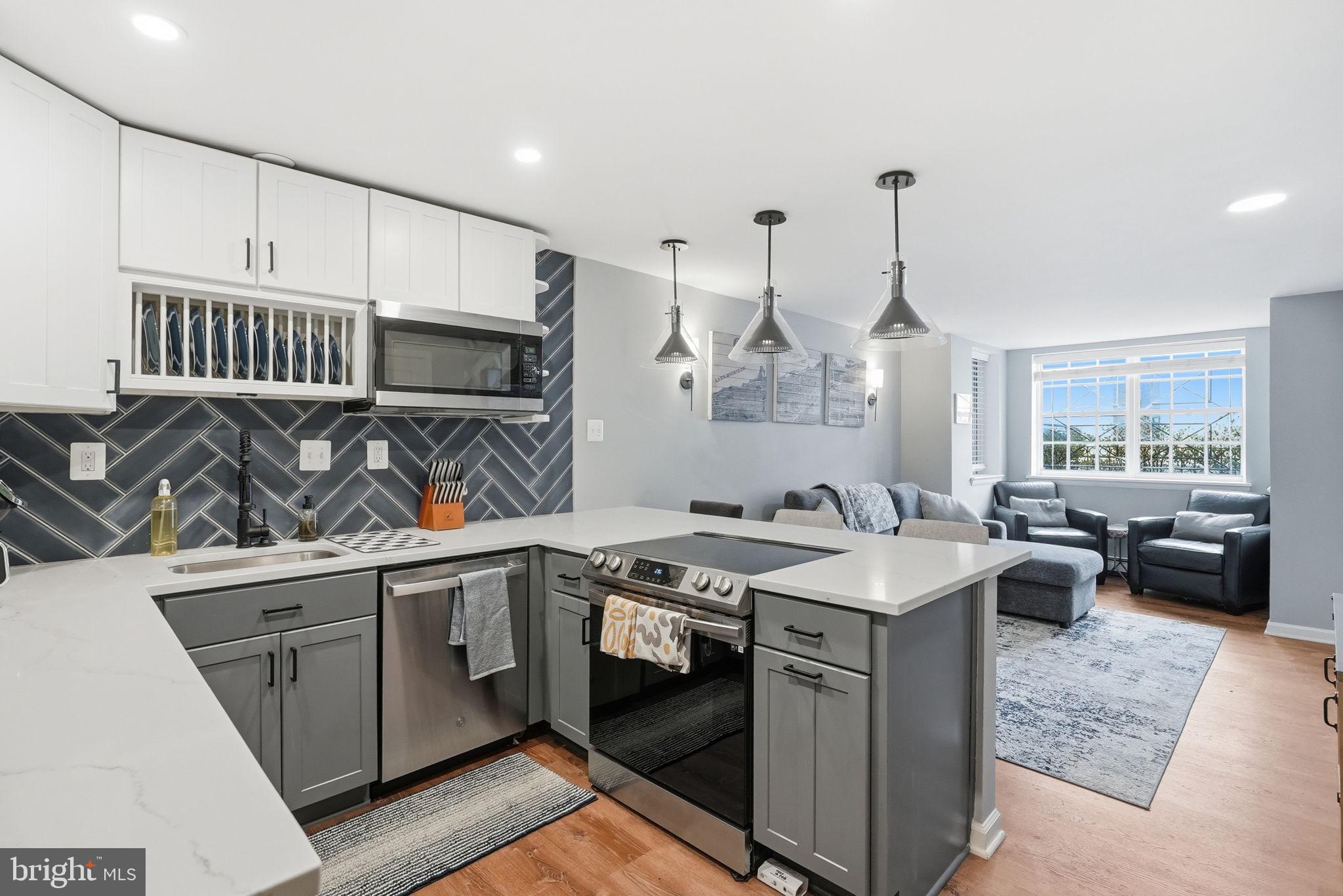 a kitchen that has a sink a stove and a wooden floor