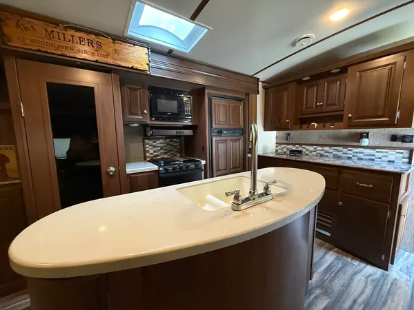a kitchen with kitchen island granite countertop a sink cabinets and wooden floor