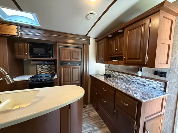 a kitchen with stainless steel appliances wooden cabinets a sink and a refrigerator