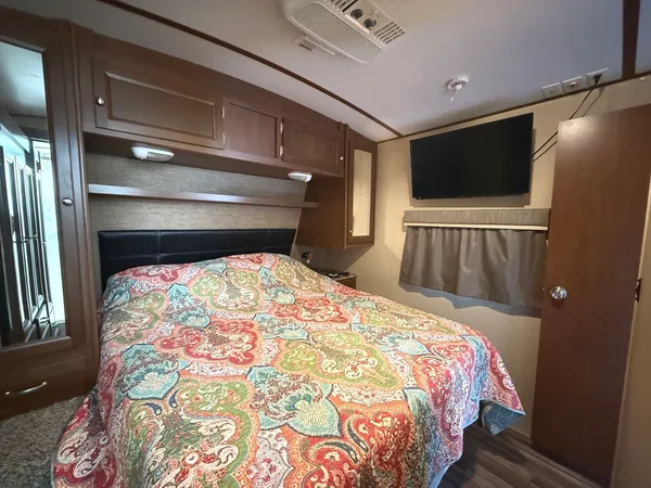 a bedroom with a bed and a flat screen tv