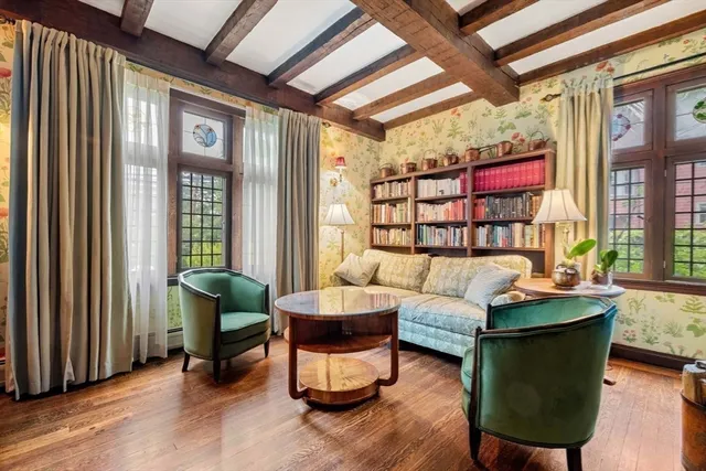a dining room with wooden floor a chandelier a wooden table and chairs