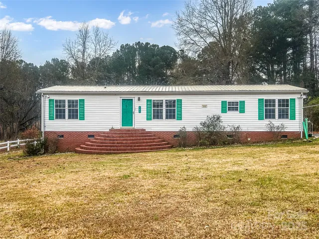 a view of a house with pool and sitting area
