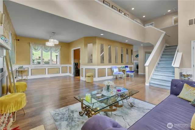 a living room with furniture and a dining table with wooden floor