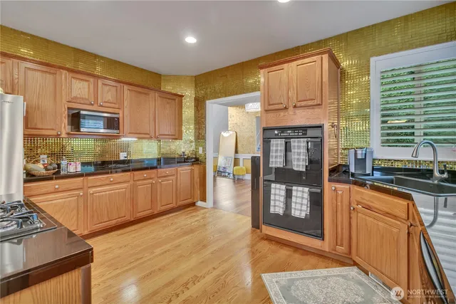 a kitchen with stainless steel appliances granite countertop wooden cabinets a stove top oven a sink and dishwasher