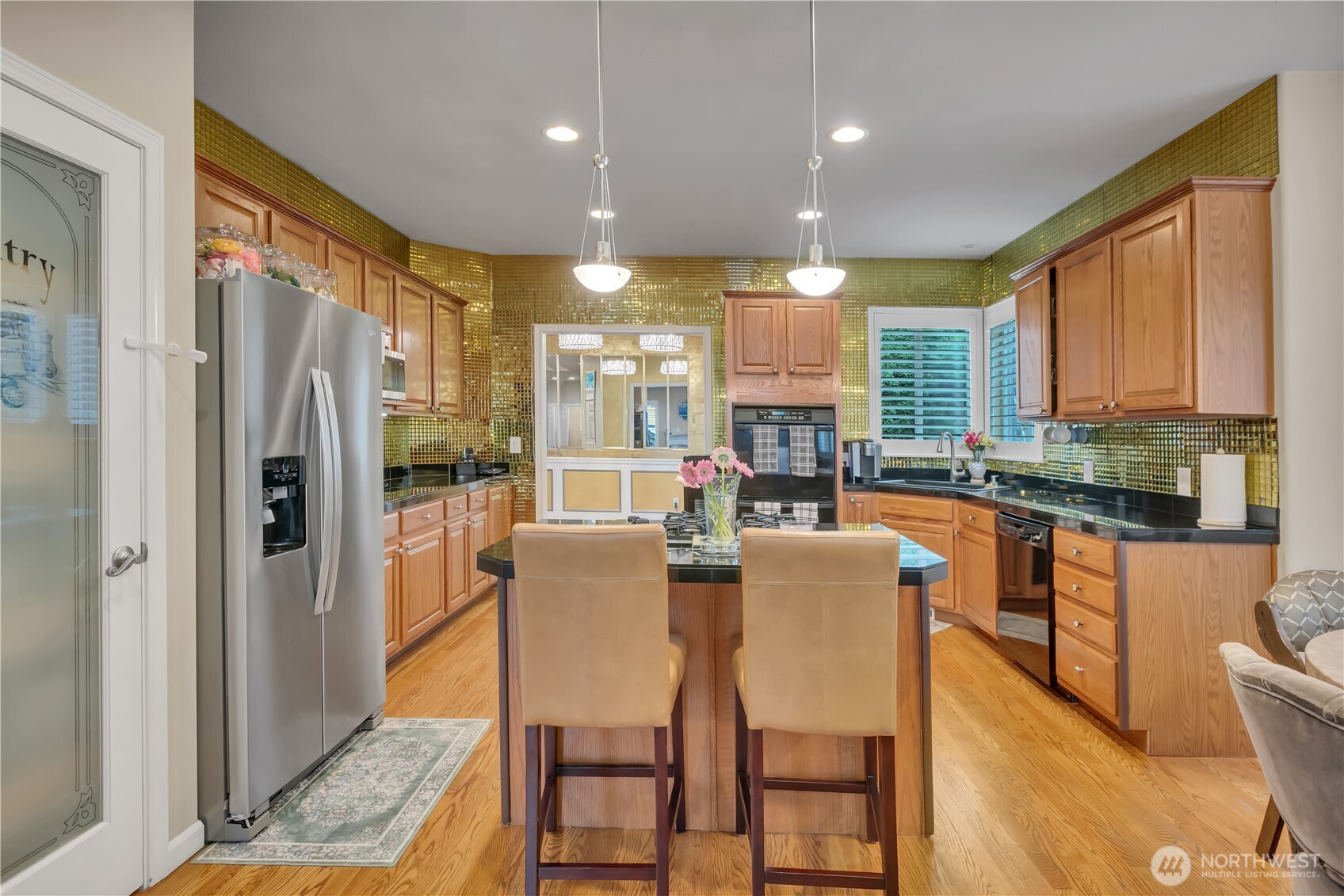 26525 Lake Fenwick Road South Kent, WA 98032 - Photo 8 of 40 a kitchen with stainless steel appliances granite countertop a refrigerator a stove top oven and a dining table with wooden floor