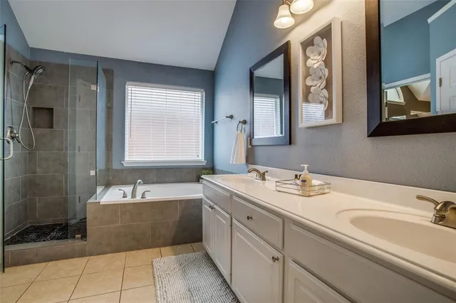 a spacious bathroom with a tub sink and mirror