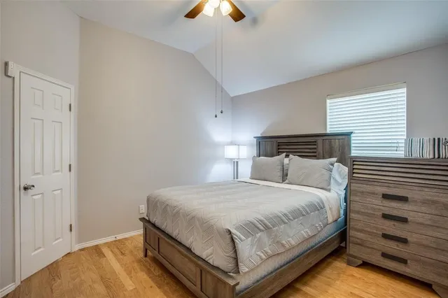 a bedroom with a bed and a chandelier fan