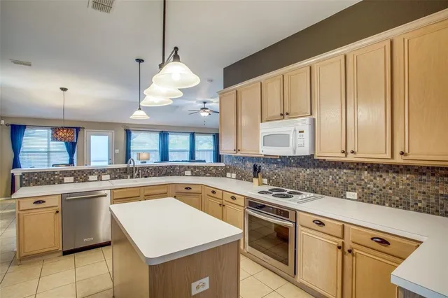a kitchen with a stove sink and cabinets