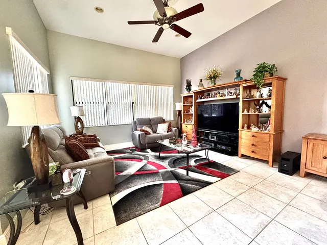 a living room with furniture a flat screen tv and a window