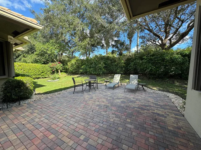 a view of backyard with a table and chairs under an umbrella