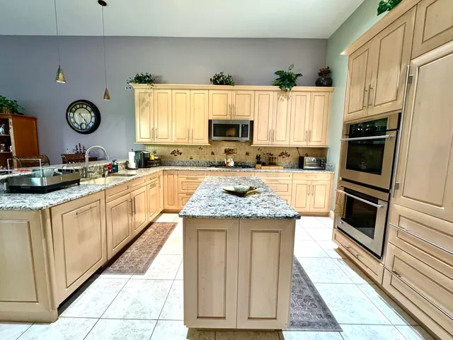 a kitchen with a sink stove top oven and refrigerator