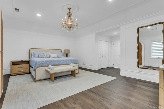 a spacious bedroom with a bed and a chandelier