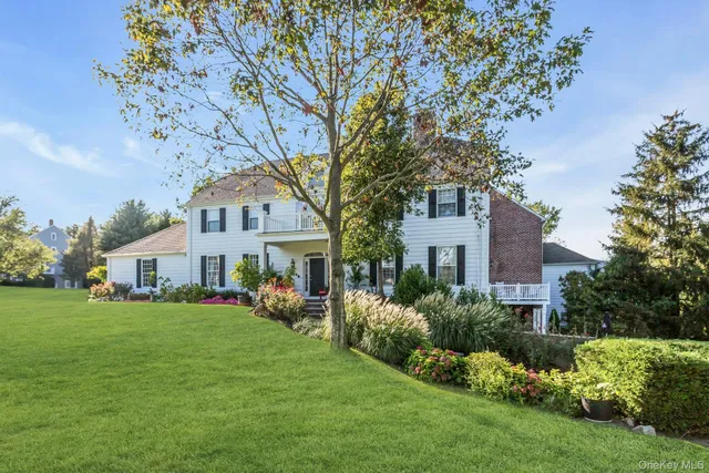 a front view of a house with a garden and trees