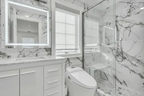 a bathroom with a granite countertop sink a toilet and a mirror