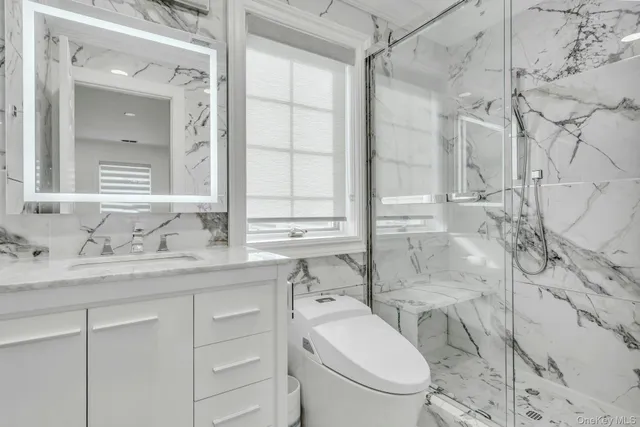 a bathroom with a granite countertop sink a toilet and a mirror