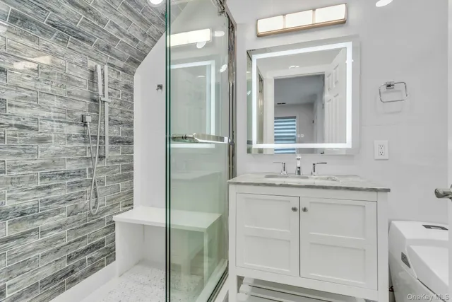 a bathroom with a granite countertop sink a toilet and a mirror