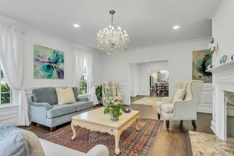 a living room with furniture and a chandelier