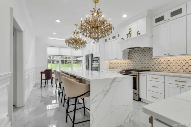 a kitchen with stainless steel appliances granite countertop a stove a sink and a white cabinets