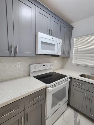 a kitchen with cabinets appliances and a sink