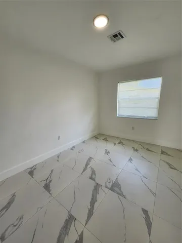a view of a backyard with plants and large tree