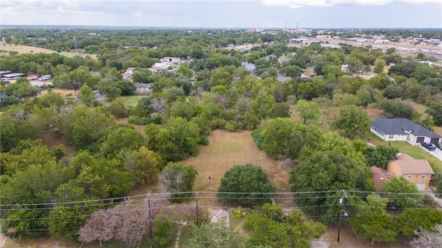 an aerial view of a house with a yard and lake view
