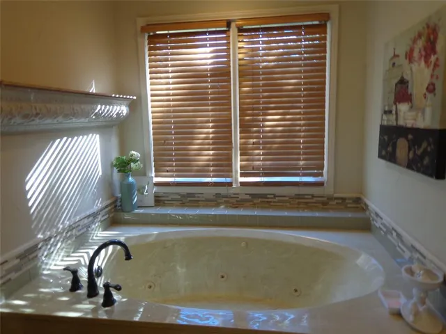 a bathroom with a tub sink and mirror