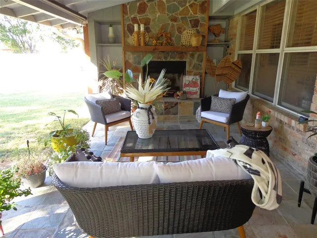 a living room with furniture a flat screen tv and a floor to ceiling window