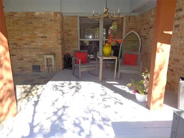a living room with patio furniture and a potted plant