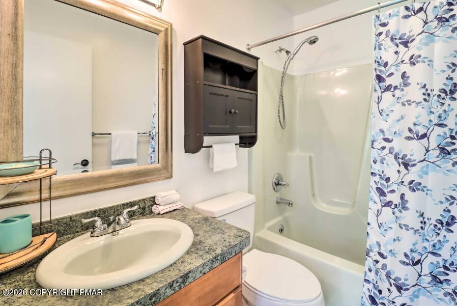 415 Alter Avenue, Unit 415 Pocono Summit, PA 18346 - Photo 11 of 21 a bathroom with a granite countertop sink toilet a shower and a mirror